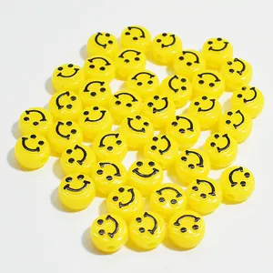 Detail view of 10mm yellow acrylic beads with black smiley face prints for DIY crafts.