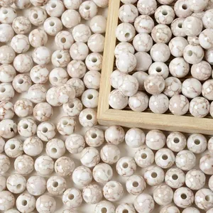 Macro view of 8mm acrylic beads with white and brown marble crackle pattern.