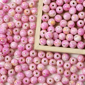 Close-up of 8mm pink marbled acrylic beads with a faux ceramic crackle finish for jewelry making.