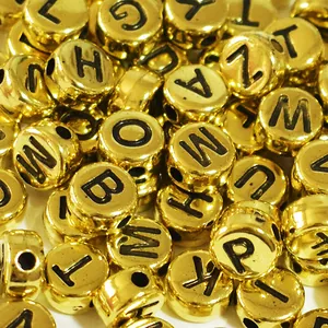 Macro close-up of golden acrylic flat round alphabet letter beads for DIY crafts