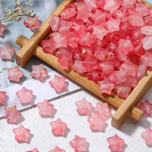 Macro detail of pink frosted star beads with gold foil for DIY jewelry making.