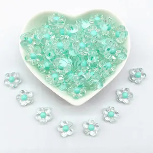 Detail view of 12mm clear acrylic flower beads with cyan centers in a heart dish