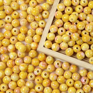 Close-up of 8mm yellow crackle acrylic beads with faux ceramic speckled finish for jewelry