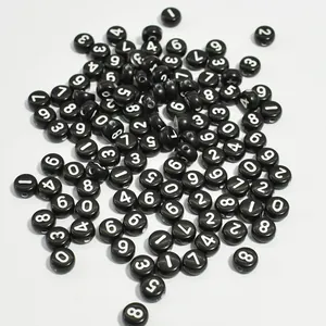 Detail shot of black acrylic round beads with white numbers for DIY jewelry making