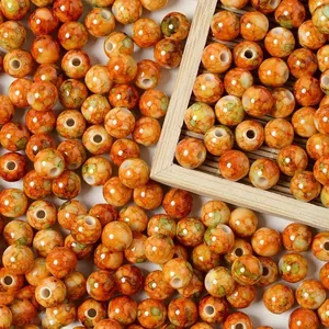 Detailed macro view of 8mm orange acrylic crackle beads with ceramic spray-point texture.