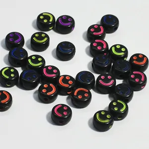 Dettaglio di perline in acrilico nero da 10 mm con vivaci motivi a faccina sorridente neon