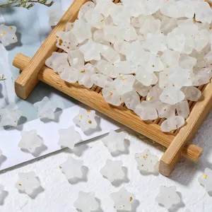 Macro detail of matte white frosted star beads with gold specks for DIY jewelry making