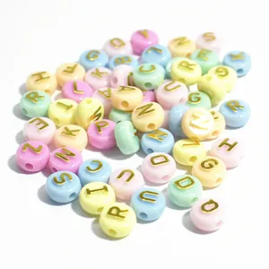 Primo piano di perline alfabetiche in acrilico macaron da 10 mm con lettere d'oro per fai da te.