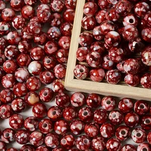 Macro view of 8mm red cracked acrylic beads with ceramic splatter effect