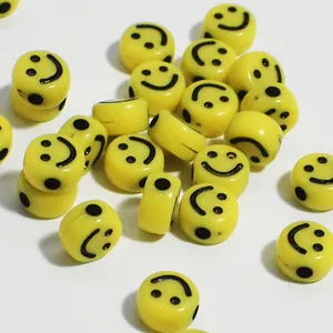 Dettaglio ravvicinato di perle smiley in acrilico giallo per creazioni di gioielli fai da te