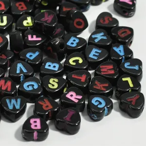 Macro detail of black heart-shaped acrylic alphabet beads for DIY jewelry design