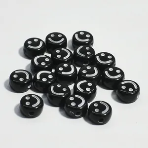 Dettaglio macro di perline tonde in acrilico nero da 10 mm con disegno a faccina