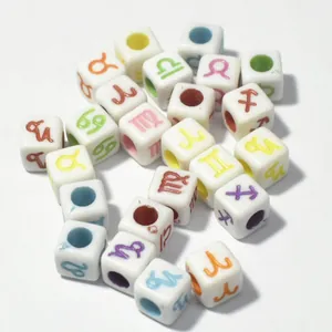 Close-up of 7mm white acrylic cube beads with colorful printed zodiac symbols