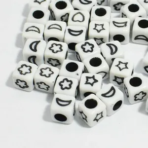 Detailed view of 6mm white acrylic square beads featuring black star and moon patterns