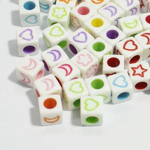 Close-up macro view of colorful 6mm acrylic cube beads with heart and star patterns