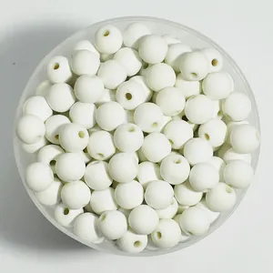 Macro view of 8mm white matte round acrylic spray-painted beads in a container