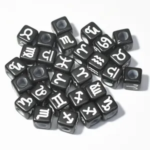 Macro detail of 7mm black acrylic square beads with white printed zodiac symbols