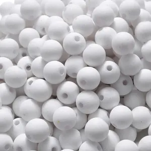Close-up macro view of white matte soft-touch acrylic beads with straight holes for DIY jewelry