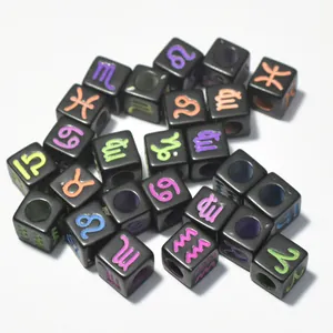 Close-up of 7mm black acrylic cube beads with colorful engraved zodiac symbols