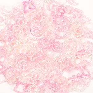 Macro view of detailed pink and white gradient pearl charms in various assorted shapes