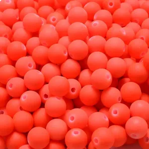 Macro detail of neon orange acrylic round beads with soft-touch rubber paint finish