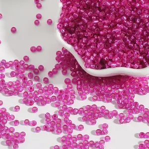 Macro detail of 2mm fuchsia glass seed beads with silver lining for jewelry making.