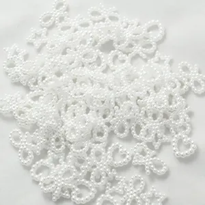 Detailed view of 10-11mm white pearl charms in star heart and bow shapes for DIY crafts