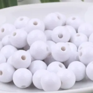 Vue macro détaillée de perles rondes en acrylique blanc lisse avec trou pour bijoux DIY