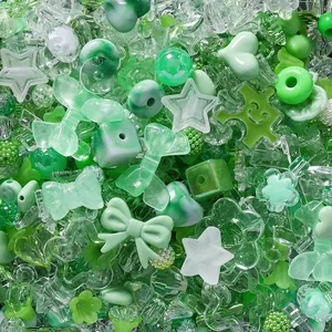 Macro detail view of mixed green and clear acrylic cartoon beads for DIY crafts