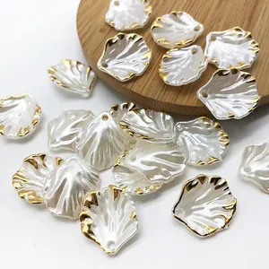 Nahaufnahme von perlweißen Acryl-Blattanhängern mit eleganten Goldkanten für DIY-Handwerk.