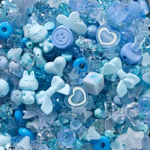 Detailed macro shot of various blue acrylic DIY beads in heart, bow, and star shapes