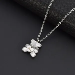 Macro detail view of silver bear pendant necklace with white shell and Love heart
