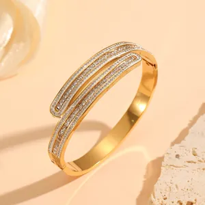 Close-up of elegant gold vacuum plated stainless steel bangle with sparkling crystal inlay