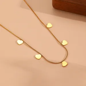 Detail view of gold-plated stainless steel snake chain necklace with five heart charms.