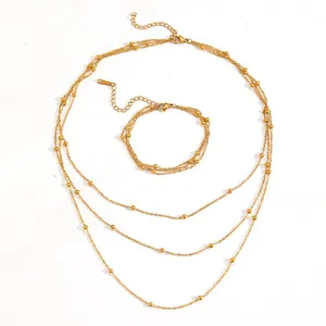 Detailed view of triple-layered gold bead chain necklace and matching bracelet set