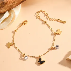 Gros plan d'un bracelet papillon en acier inoxydable doré avec breloques en cristal.