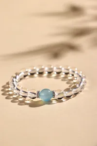 Macro-detailweergave van een bergkristal kralenarmband met een centrale aquamarijn
