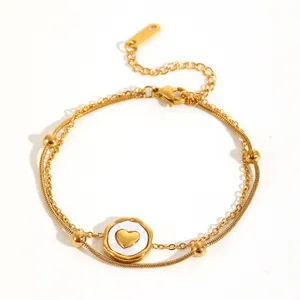 Close-up detail of double-layer stainless steel anklet with golden heart pendant