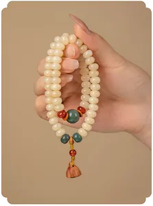 Detail van crèmegele Bodhi-wortel gebedskralen met een houten lotusbloem hanger