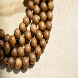 Detailed macro view of 4mm green sandalwood prayer beads in yellowish-brown color
