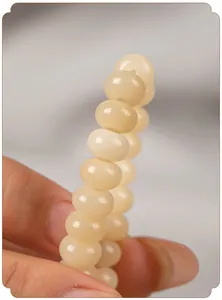 Detailopname van roomgele Bodhi-wortelkralen met een gladde gepolijste afwerking.