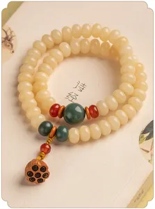 Macro-detail van dubbele lus crème Bodhi wortel armband met lotus pod charme.