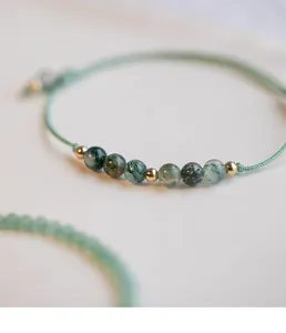 Primer plano detallado de pulsera de ágata musgo natural con cuentas de oro 14k