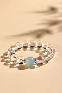 Detailopname van kristal en aquamarijn kralenarmband met elegante bladschaduwen