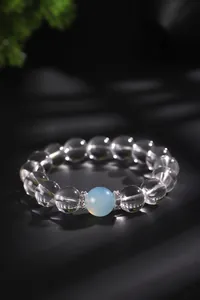 Macro-opname van witte kristallen kralen met blauwe edelsteen onder dramatisch licht.