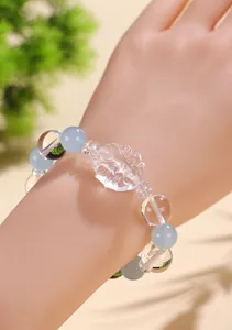 Dettaglio del ciondolo volpe a nove code in quarzo su bracciale di perle azzurre