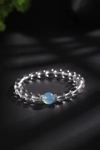 Close-up van elegante bergkristal armband met lichtblauwe aquamarijn kraal