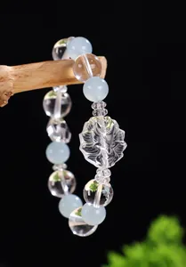 Dettaglio ravvicinato di volpe a nove code in cristallo intagliato su bracciale di perle