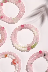 Dettaglio di eleganti braccialetti a doppio strato in quarzo rosa e agata bianca perlata