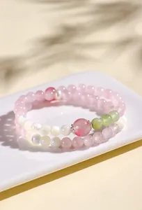 Elegante bracciale a doppio filo in quarzo rosa e agata bianca su un vassoio bianco
